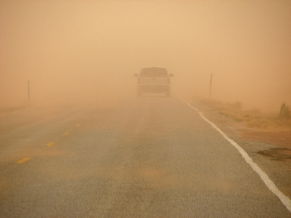 Driving along a highway into an orange sandstorm, visibility is reduced drastically. (iStock │ #140469297 - pancaketom)