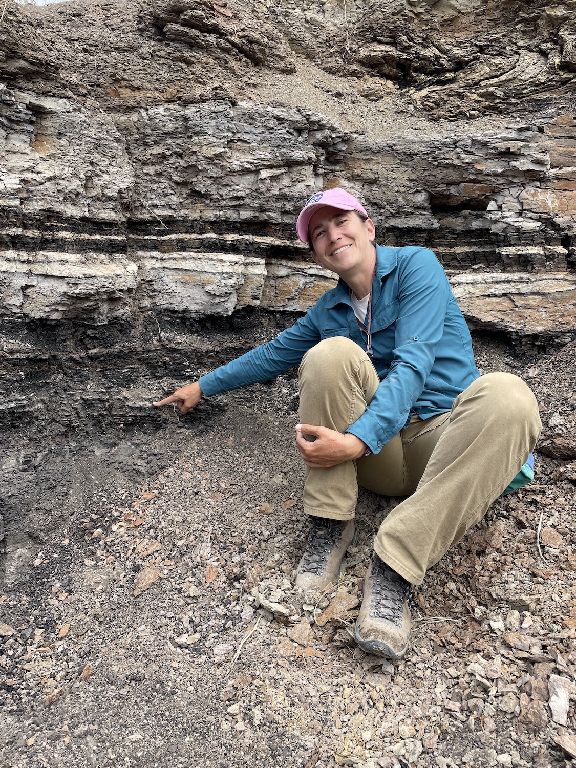 UW Professor Ellen Currano touches the Cretaceous/Paleogene (K-Pg) boundary in the Denver Basin. (Photo by Regan Dunn.)