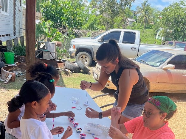 Jayden Grider and Ruthann Corker do a bead craft with children. (Photo courtesy of University of Arkansas-Monticello.)