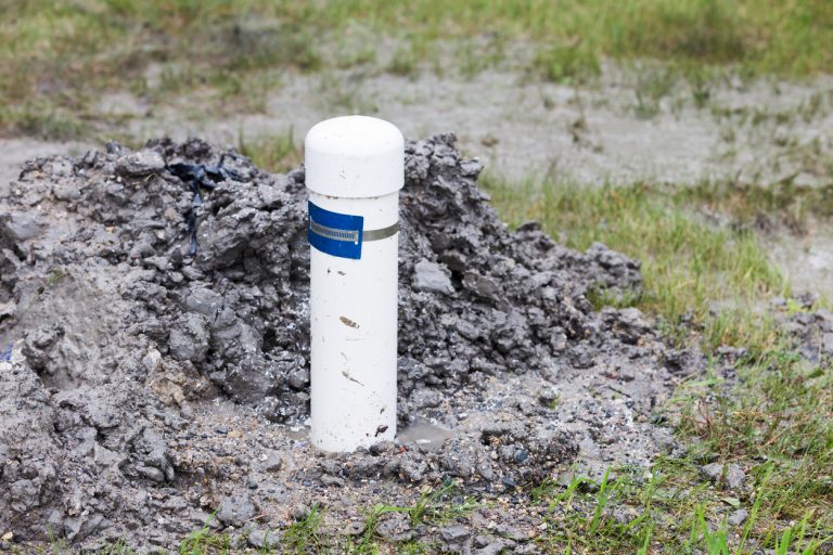 Close-up image of the equipment and process of drilling a new residential water well. Here is the finished, capped and tagged pcv pipe of the property's new water well. (Photo: iStock - skhoward)