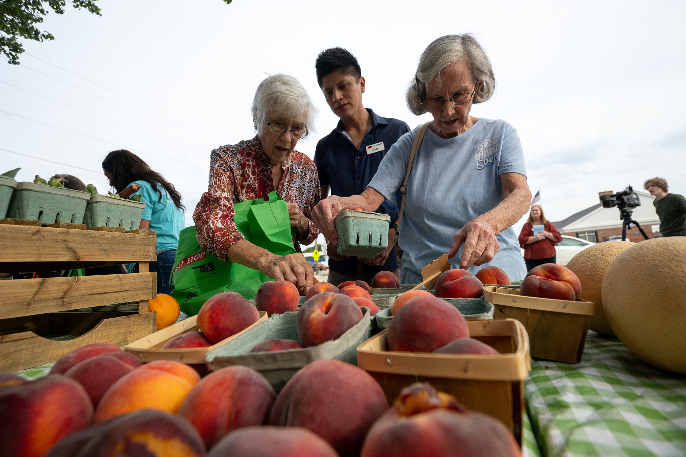 Leo Perez, center, Oklahoma State University Extension educator, special projects, helps senior residents in Haskell, Oklahoma, select locally grown fruits and vegetables during the downtown Mobile Market. (Photo by Mitchell Alcala, Oklahoma State University Agriculture.)