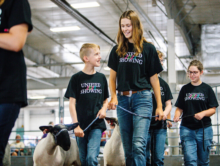 Josh Layman, showman, (left), leads his lamb as a member of the Unified Showing 4-H Club, accompanied by buddy Tatum Terwilliger. Josh, one of the first members of the club, has honed his skills over the years and this summer was the lightweight champion in the sheep show at the Lancaster County Fair. (Delynn Day/3D Imaging)