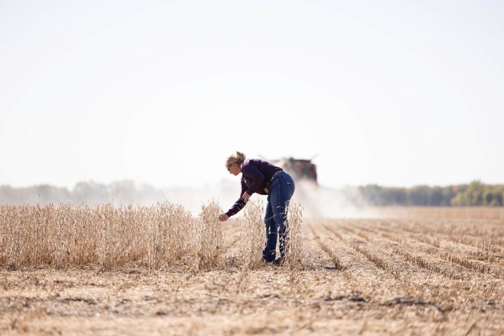 Jacquelyne Leffler checks out the soybean crop as her dad drives the combine on their farm near Americus, Kansas. Returning to the family farm wasn’t initially in her plan, but the 33-year-old realized after college how she wanted to continue her family legacy and become the fourth generation on the farm. (Photo courtesy of Travis Carroll.)