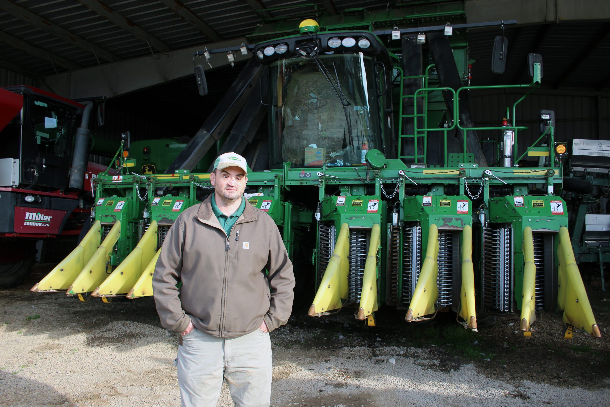 Jonathan Evans poses in front of the cotton picker. (Journal photo by Lacey Vilhauer.)