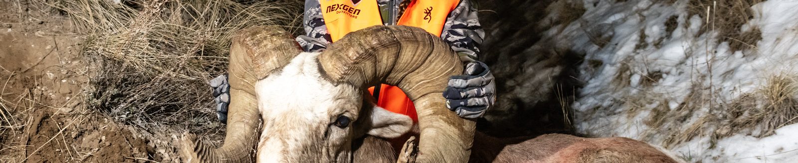 Kiersten Black, 15, poses with the bighorn sheep ram after her successful hunt. (Photo by Justin Haag, Nebraskaland Magazine and Nebraska Game and Parks Commission.)