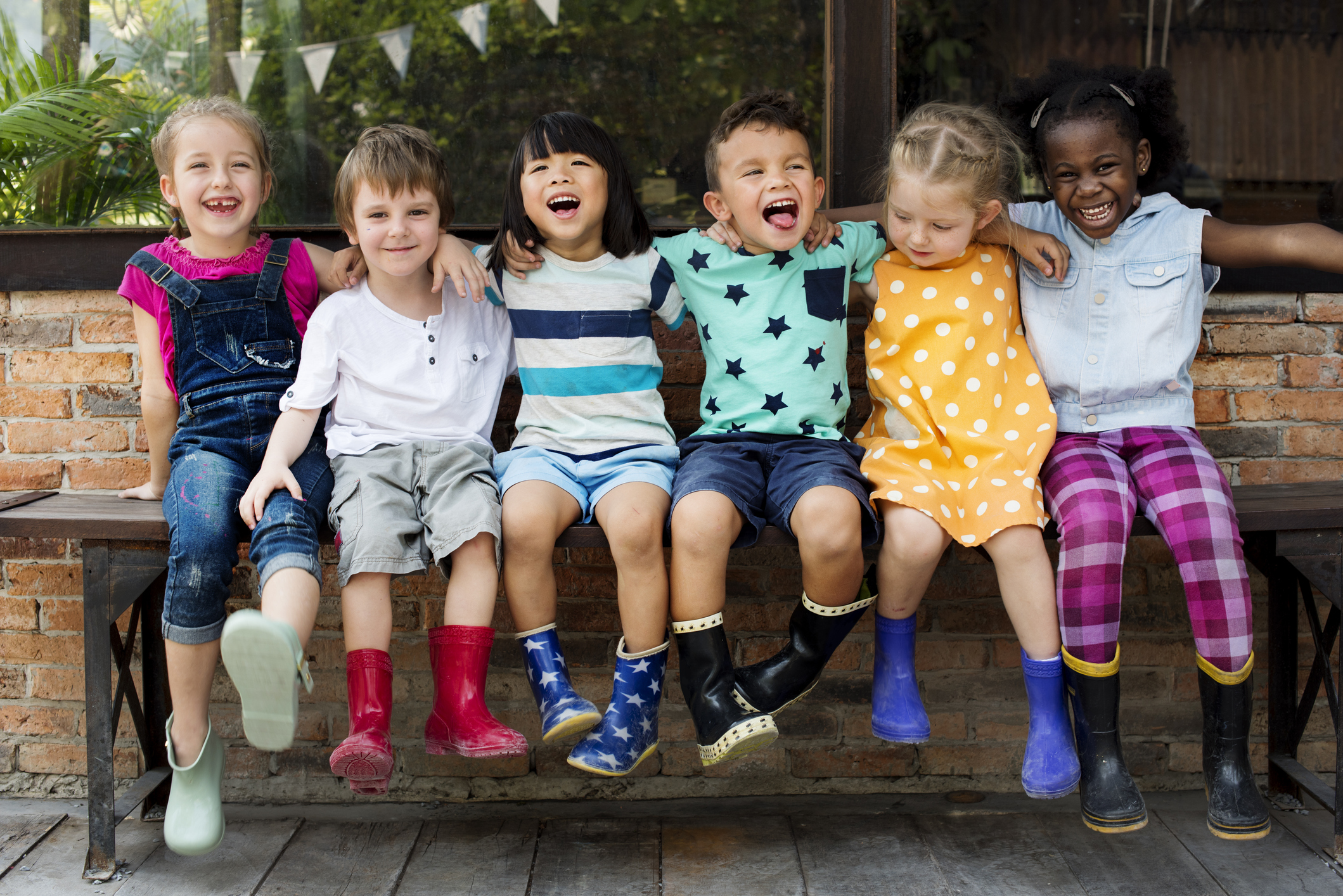 Kindergarten kids friends arm around sitting smiling (Photo: iStock - Rawpixel)