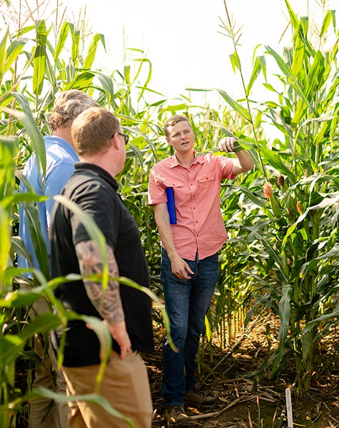 Insignum AgTech CEO Kyle Mohler (right) speaks with farmers about the company’s corn plants during its summer 2023 field day. These plants use naturally occurring pigment to signal when specific plant stresses begin. (Insignum AgTech photo/Chalais Randle Photography.)