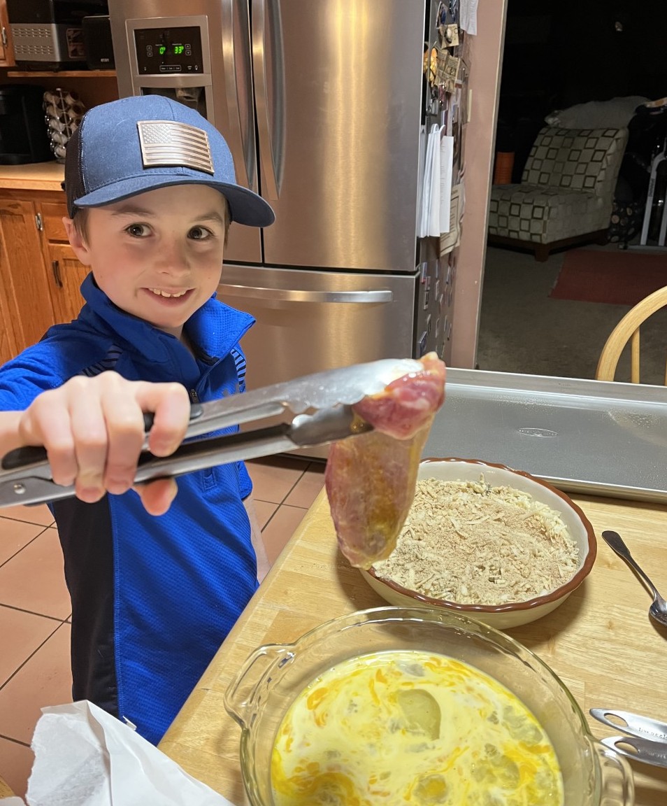 Remington Decker, a young chef in Albany County, helps prepare a family meal as part of the Wyoming Food, Fun, 4-H program. (Photo courtesy of University of Wyoming Extension.)