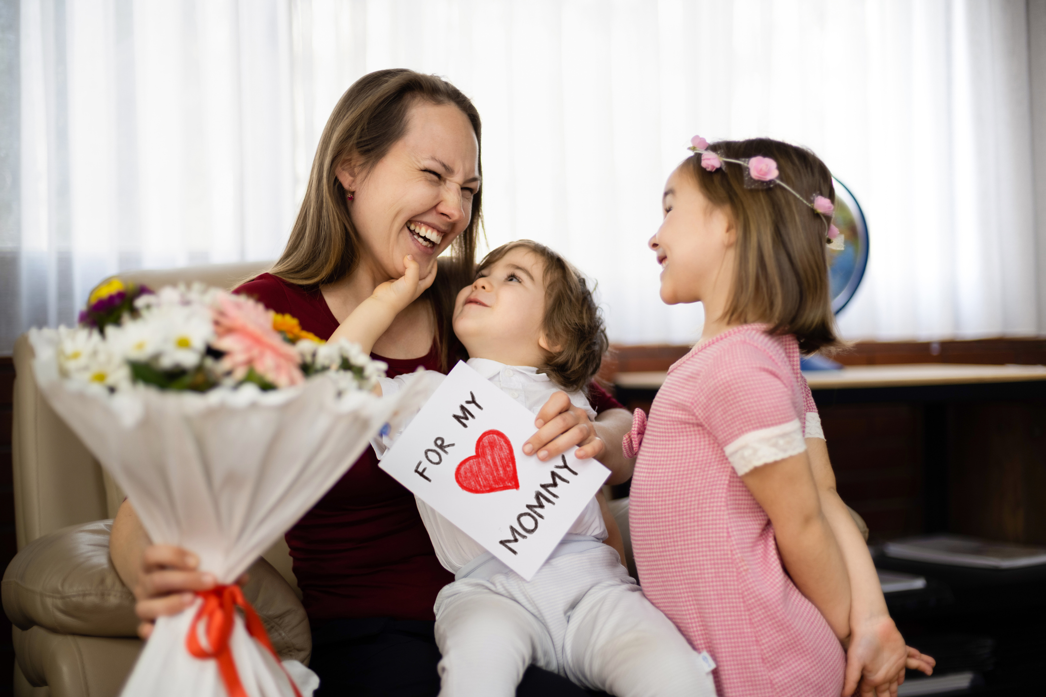 Children Surprising Mother On With Bouquet And Greeting Card (Photo: iStock - ilkercelik)