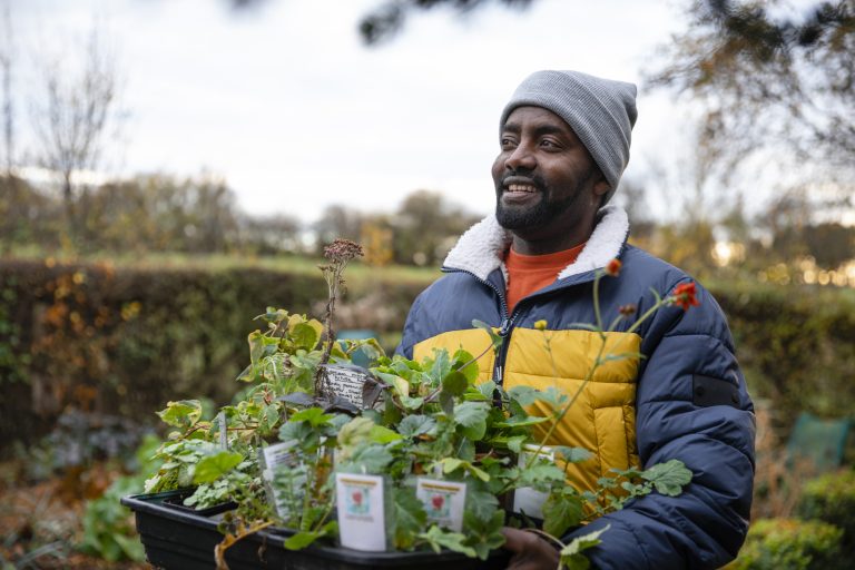 Small business owner holding a tray of plants he has for sale. (Photo: iStock - SolStock)