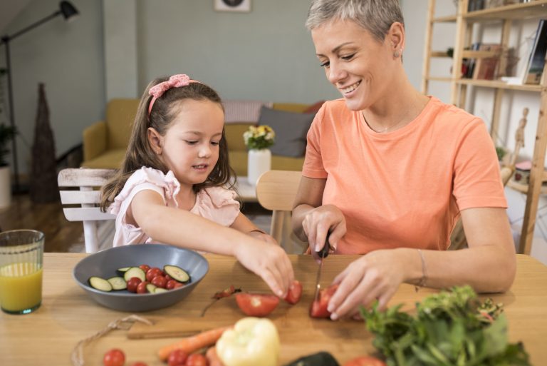 Little girl and her mother preparing lunch at home. (Photo: iStock - MixMedia)