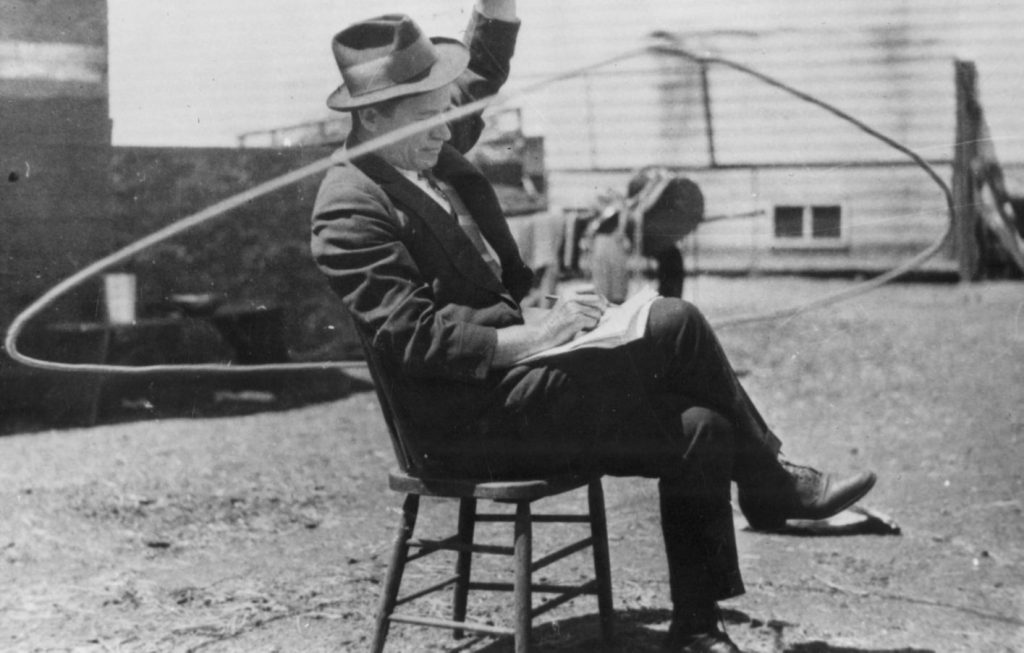 Will Rogers reads a newspaper and twirls a lasso on a movie set. (Photo courtesy Will Rogers Memorial Museum.)