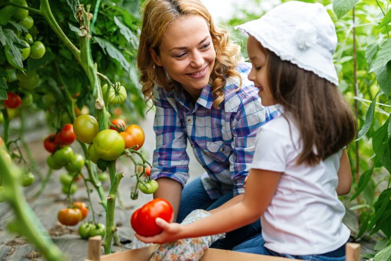 Woman and child growing plants in farm garden (Photo: iStock - nd3000)