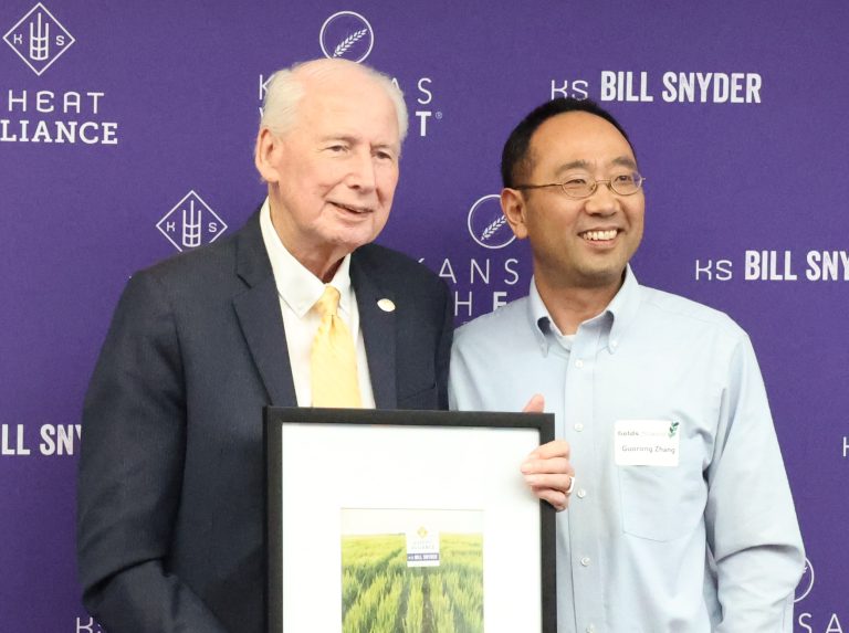 Wheat breeder Guorong Zhang developed the KS Bill Snyder wheat variety, using parents from the Hays and Manhattan breeding programs. He is pictured with the variety’s namesake, Coach Bill Snyder. (Photo by Bill Spiegel.)