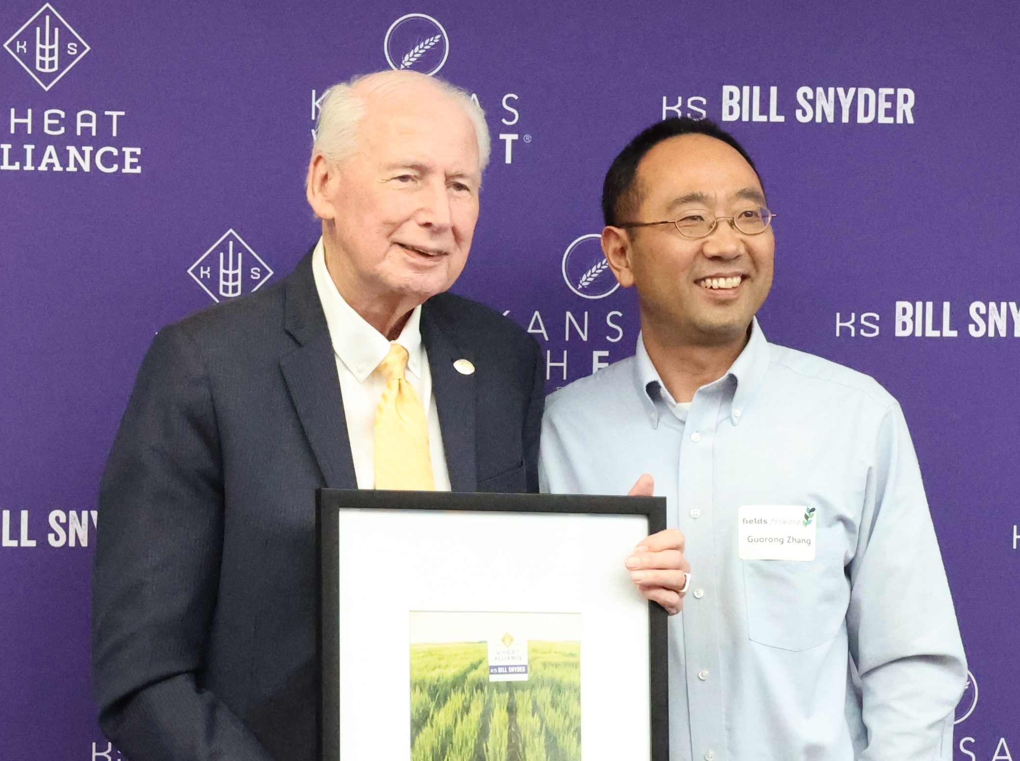 Wheat breeder Guorong Zhang developed the KS Bill Snyder wheat variety, using parents from the Hays and Manhattan breeding programs. He is pictured with the variety’s namesake, Coach Bill Snyder. (Photo by Bill Spiegel.)