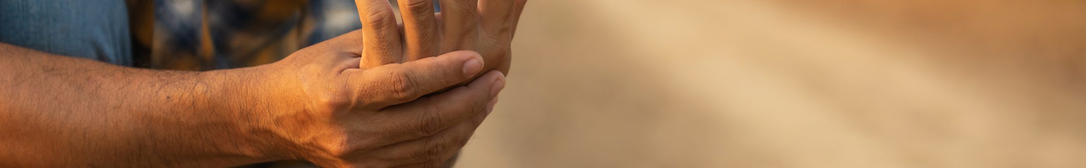 Injuries or Illnesses that can happen to farmers while working. Man is using his hand to cover over wrist because of hurt, pain or feeling ill. (Photo: iStock - PhanuwatNandee)