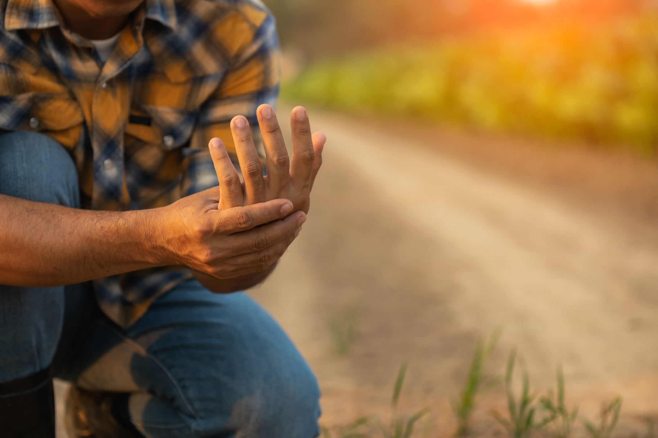 Injuries or Illnesses that can happen to farmers while working. Man is using his hand to cover over wrist because of hurt, pain or feeling ill. (Photo: iStock - PhanuwatNandee)
