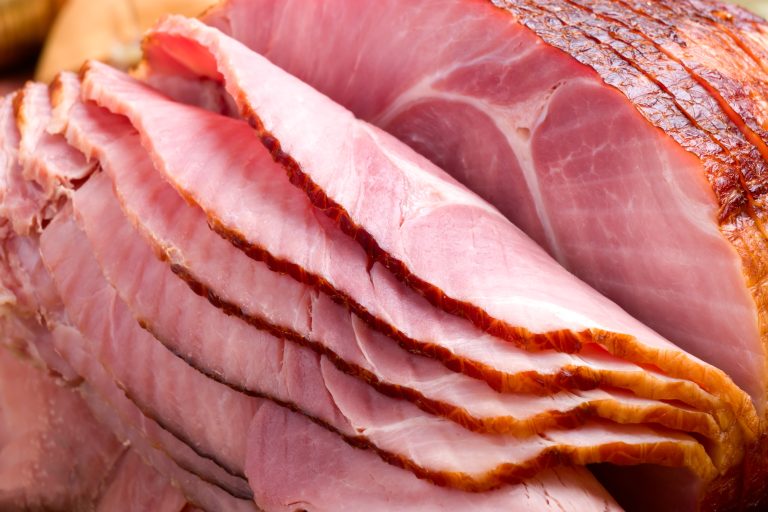 Closeup of delicious whole baked sliced ham with fresh strawberries and figs on holiday table. (Photo: iStock - evgenyb)