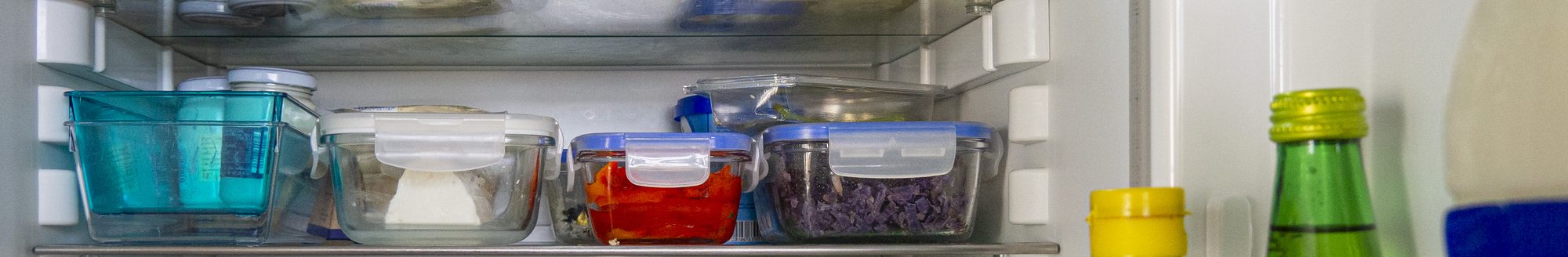 Open fridge with food leftovers and meal plan in glass containers. Domestic refrigerator for healthy eating. Leftover food, yogurt, cheese and other groceries. (Photo: iStock - Olga PS)