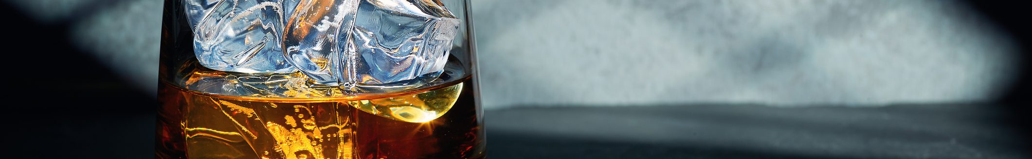 Late night glass of malt whisky with ice on a slate table with moonlight through the window on the wall behind. (Photo: iStock - lucentius)
