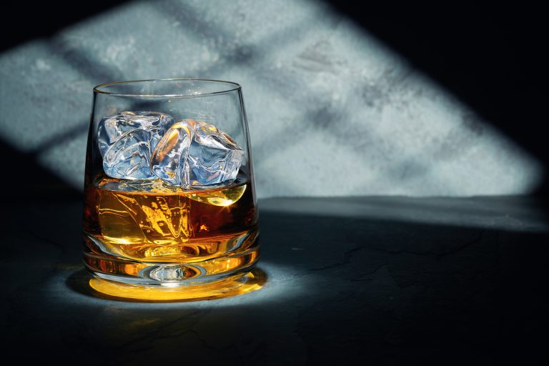 Late night glass of malt whisky with ice on a slate table with moonlight through the window on the wall behind. (Photo: iStock - lucentius)