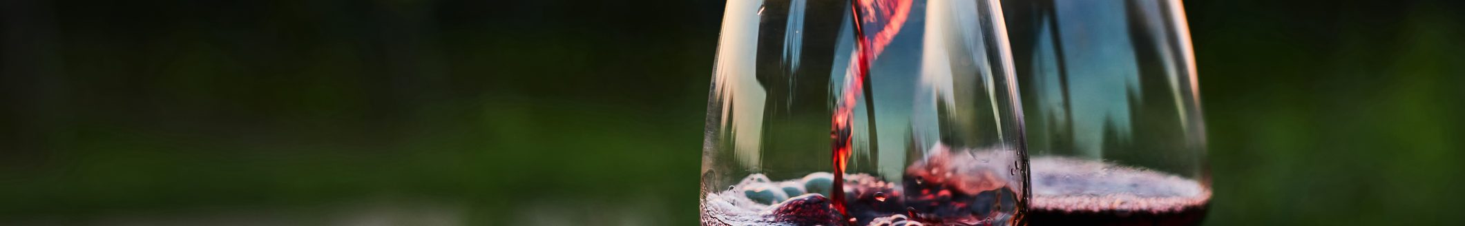 Pouring red wine into glasses on the barrel at dusk (Photo: iStock - Rostislav_Sedlacek)