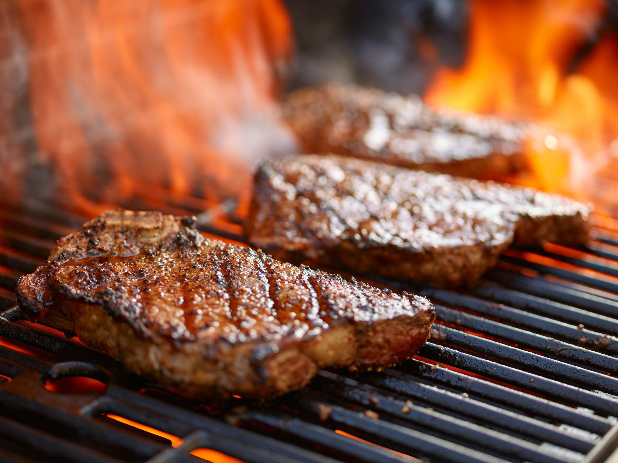 Grilling steaks on flaming grill (Photo: iStock - rez-art)