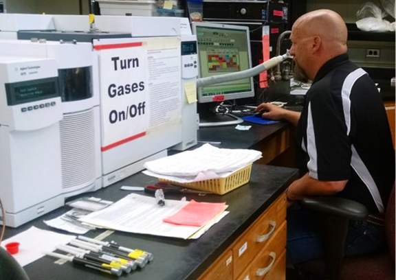 Chris Kerth, Ph.D., associate professor of meat science in the Texas A&M Department of Animal Science, sniffs the volatile aroma compounds as they exit the gas chromatograph to correlate the aroma descriptor with the chemical aroma compound. (Texas A&M AgriLife)