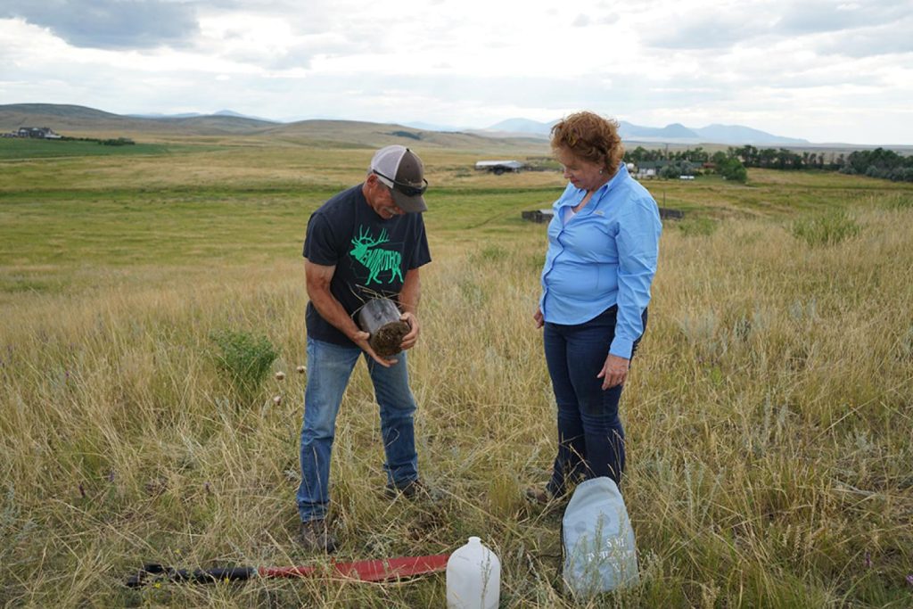 Landowner Rick Caquelin and NRCS District Conservationist Pam Linker measure determine the water to soil infiltration rate on a pasture. (USDA NRCS Montana)