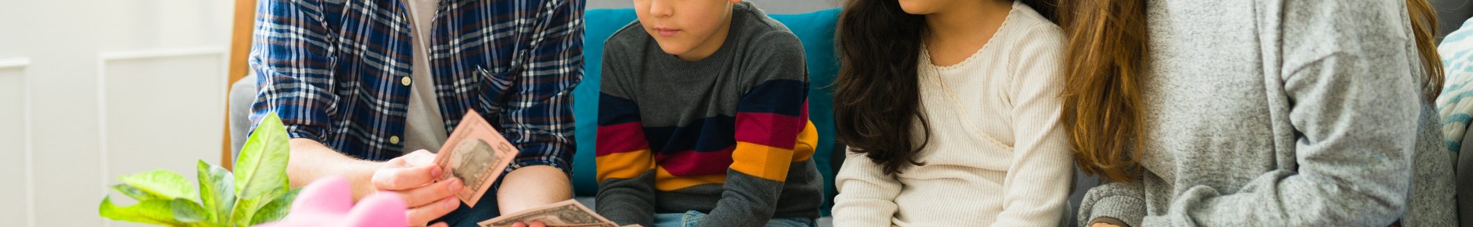 Caring parents teaching financial education to their children while counting money together to put in the piggy bank (Photo: iStock - Antonio_Diaz)