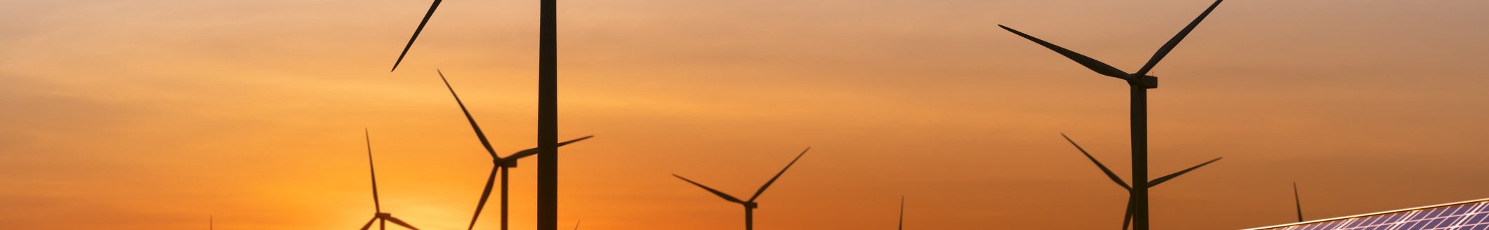 Wind turbine and a solar panel at sunset. Sustainable energy source for smart cities. (Photo: iStock - bombermoon)