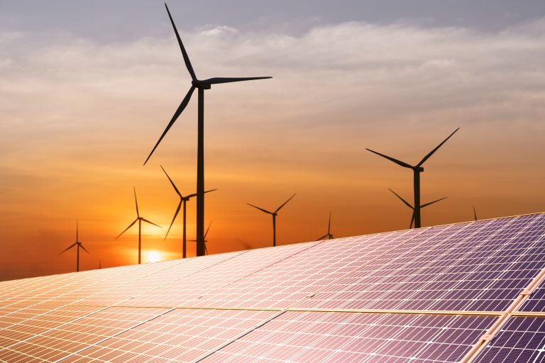 Wind turbine and a solar panel at sunset. Sustainable energy source for smart cities. (Photo: iStock - bombermoon)