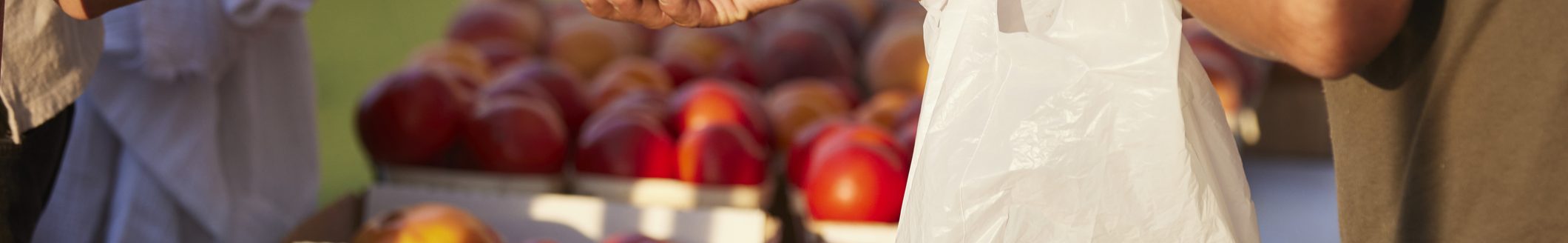 Farmer at market hands purchase to customer over colorful blend of organic produce (Photo: iStock - Donte Tatum)