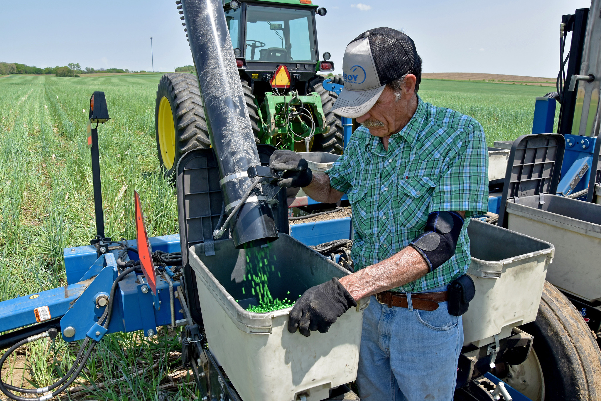 A farmer pours soybean seed into his planter prior to no-till planting into cereal rye. (Photo courtesy of Jason Johnson/Iowa NRCS)