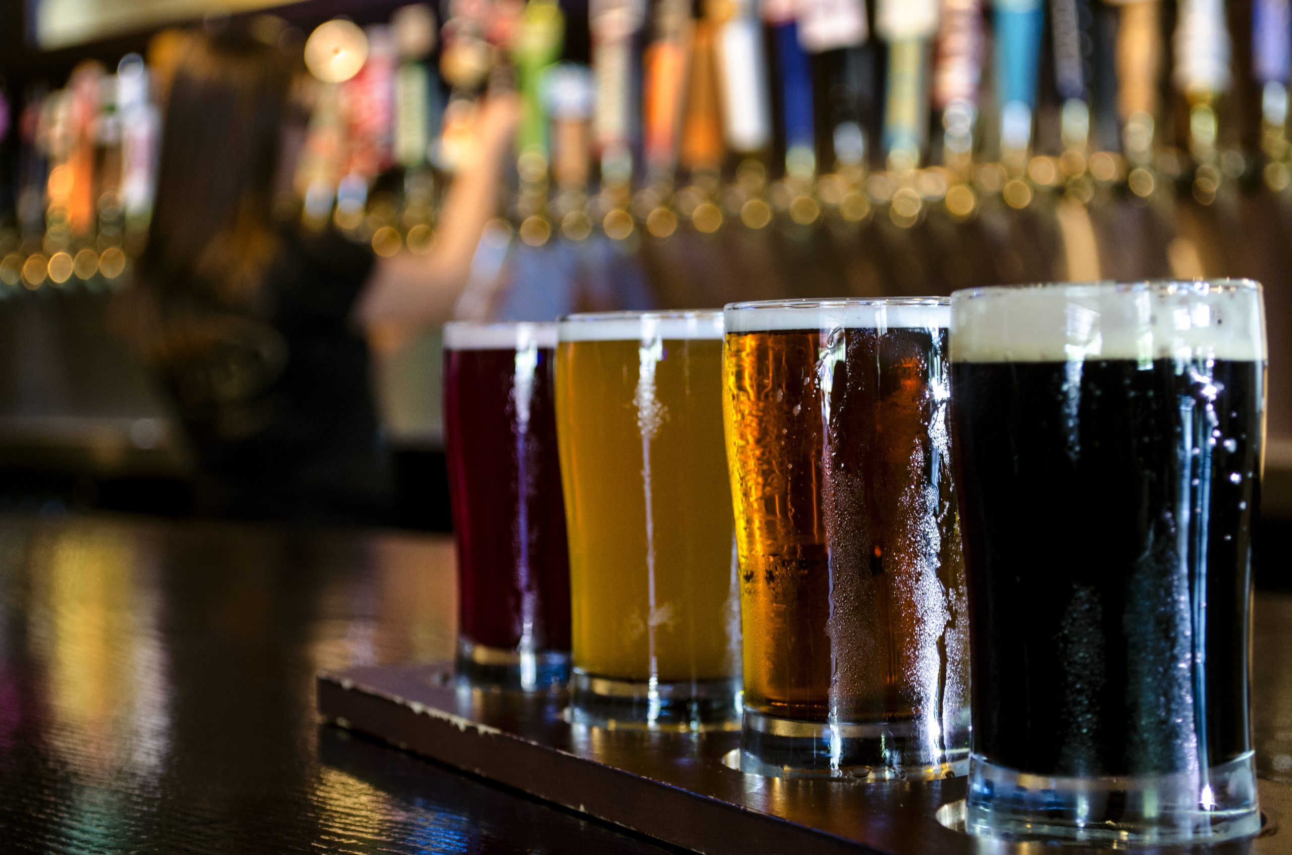 A flight of 4 craft beers lined up on the bar. (Photo: iStock - blizzard_77)