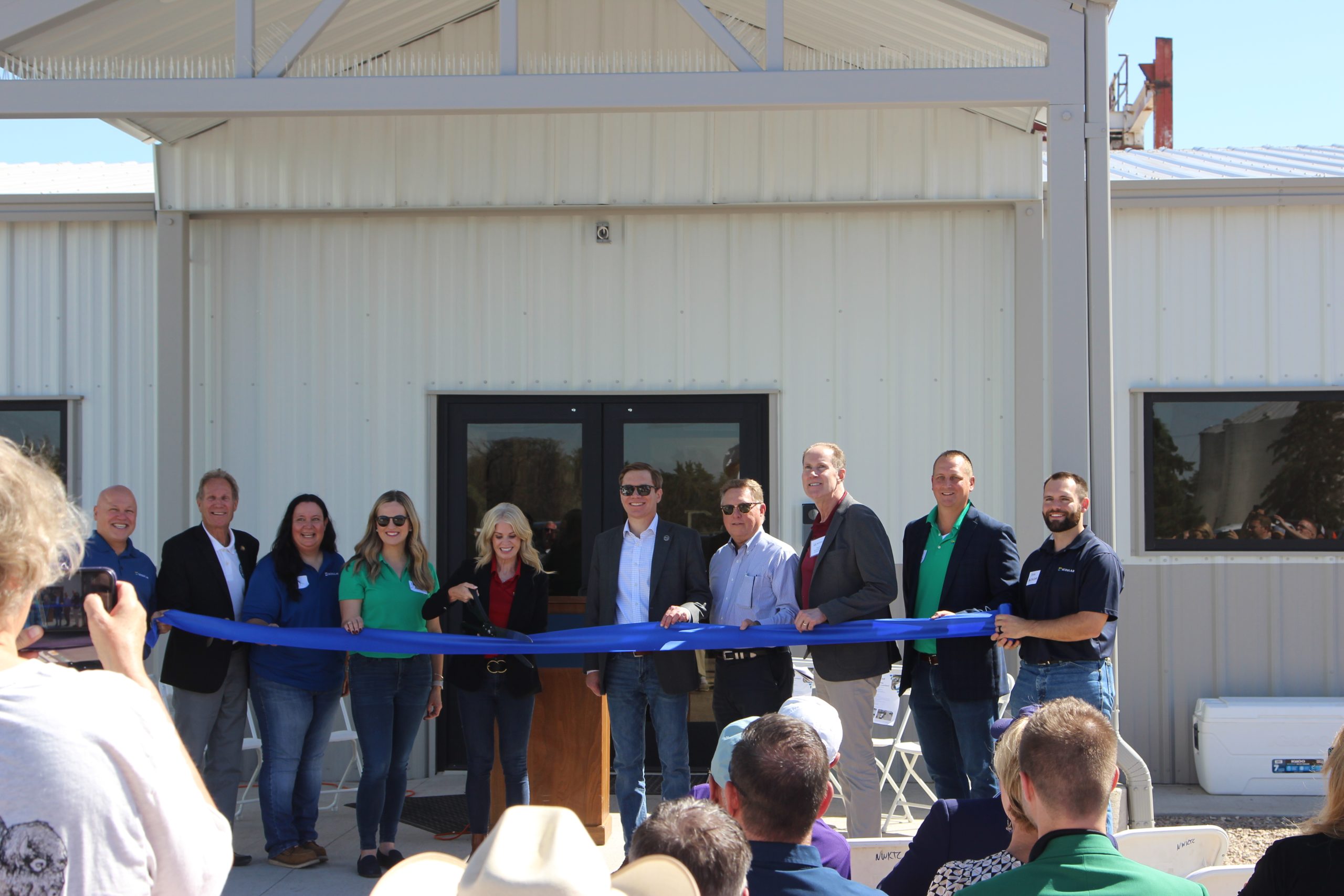 Sandra Hulm, senior vice president of the oilseeds and renewable division at Scoular, cuts a ribbon signifying the opening of the company’s canola and soybean crush plant near Goodland, Kansas. Among the dignitaries who assisted with the Sept. 18 event were (pictured to her left) Lt. Gov. David Toland and Secretary of Agriculture Mike Beam. (Journal photo by Dave Bergmeier.)