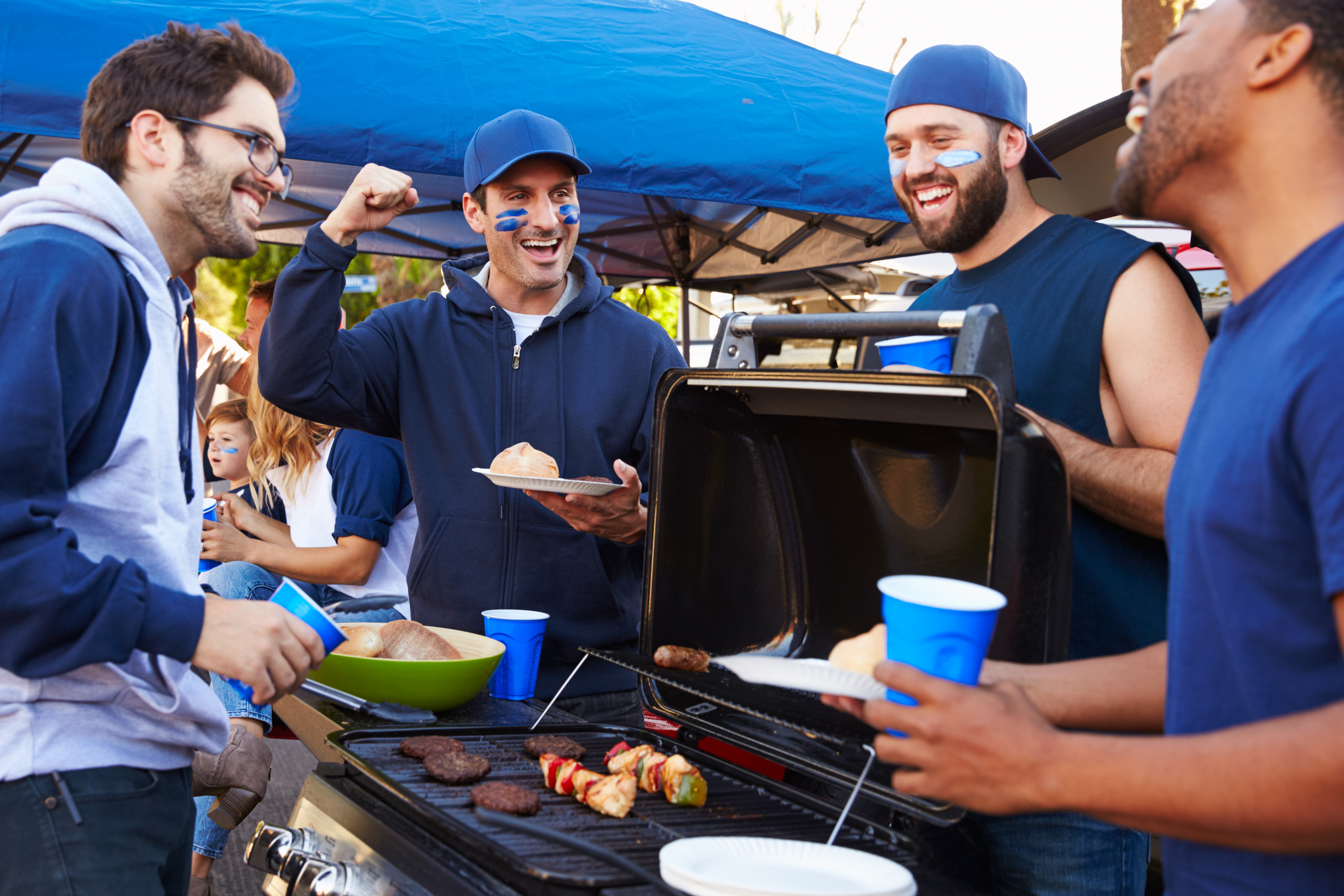 Group Of Male Sports Fans Tailgating In Stadium Car Park (Photo: iStock - monkeybusinessimages)