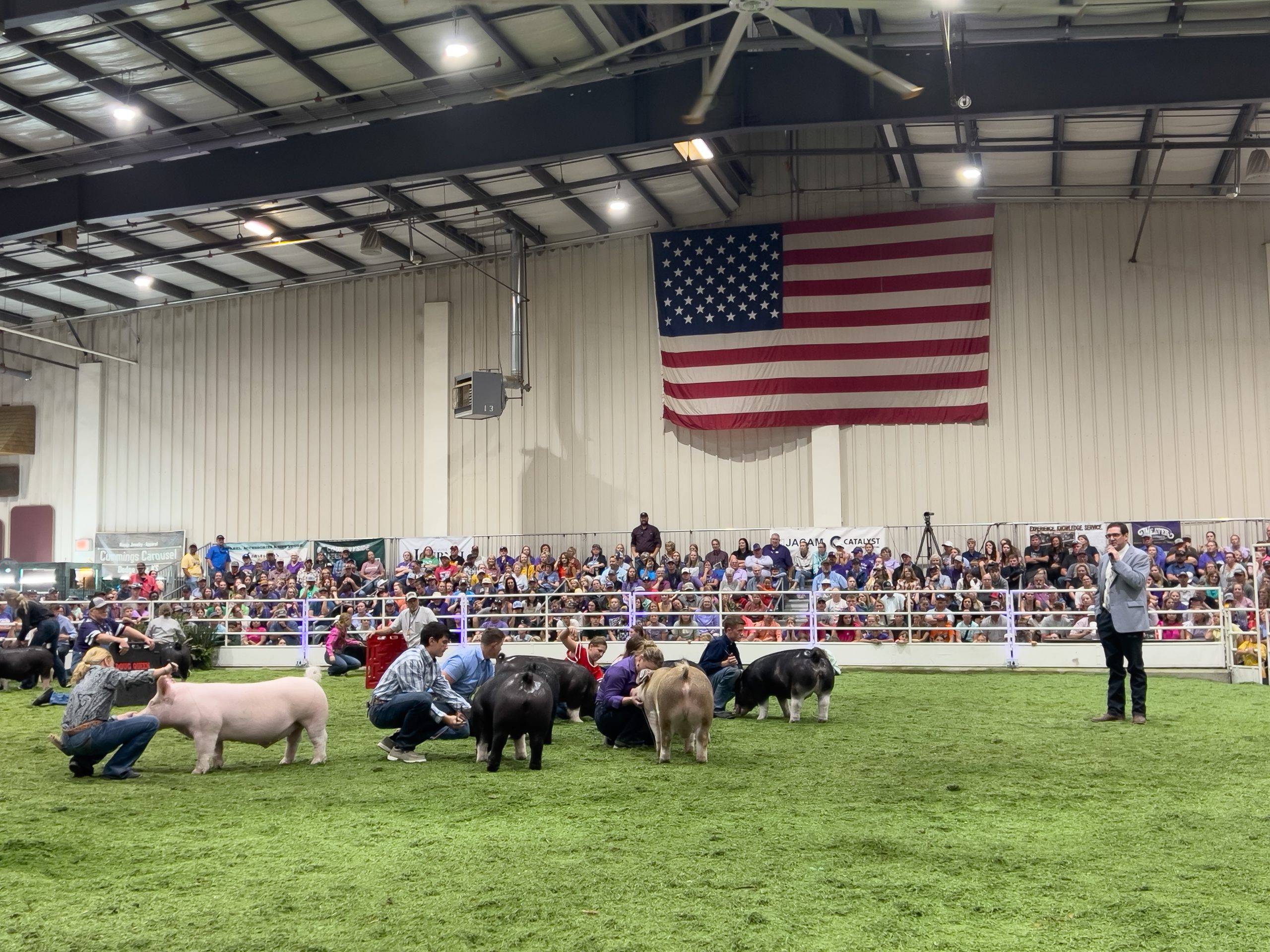 Kansas State Fair swine judge Clay Zwilling, right, talks about the importance of showing before he picked the champion market hog. (Journal photo by Kylene Scott.)