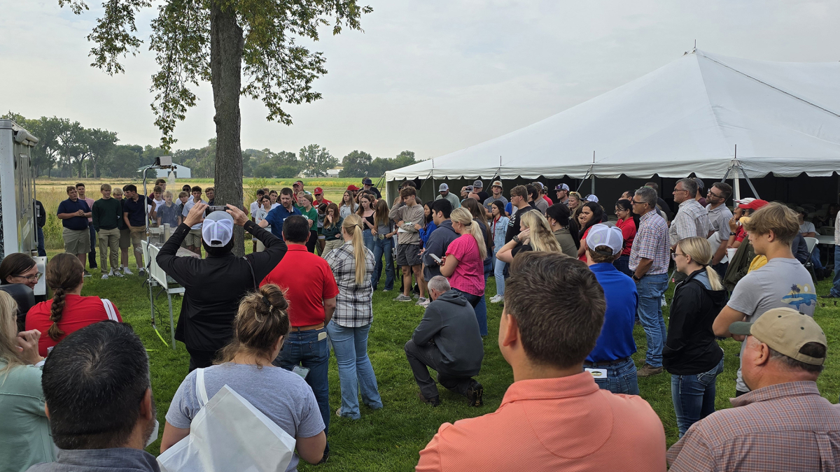 A crowd gathers around the USDA NRCS live rainfall simulator which demonstrates the outcome of different soil health practices, led by Nathan Meuller, USDA NRCS state soil health specialist, at the WCREEC Water, Crops and Soil Health Field Day on Sept. 5. (Photo by Bijesh Maharjan)