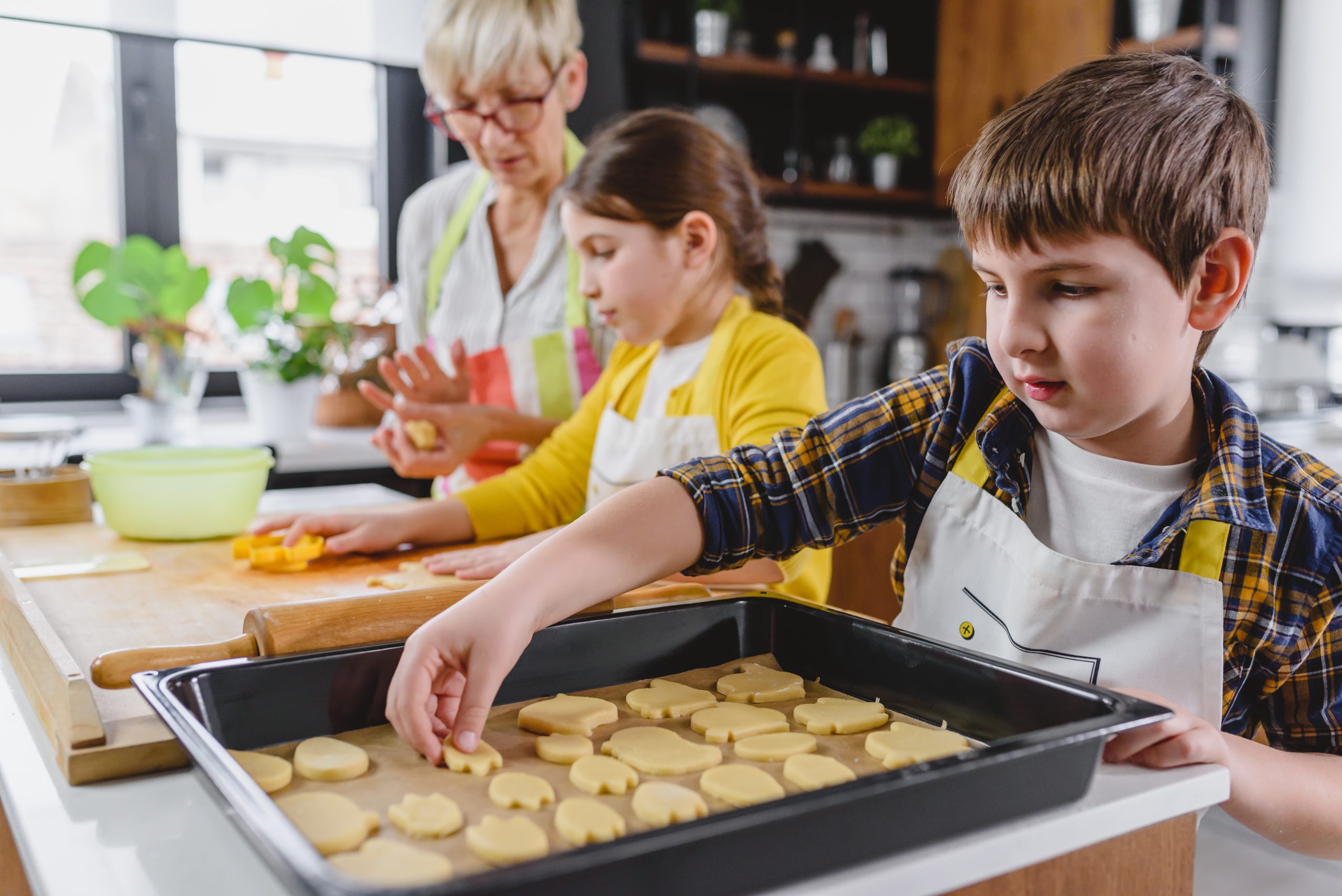 Grandmother baking cookies with her grandchildren at home. (Photo: Adobe Photo Stock - lordn)