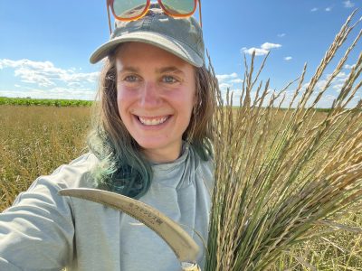 Hannah Rodgers holding a Kernza plant. (Photo by Hannah Rodgers)