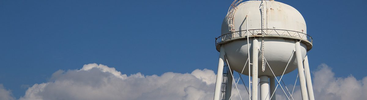 Water Tower with Clouds. (Photo: Adobe Stock │ #214397650 - MitchCoxPhoto)
