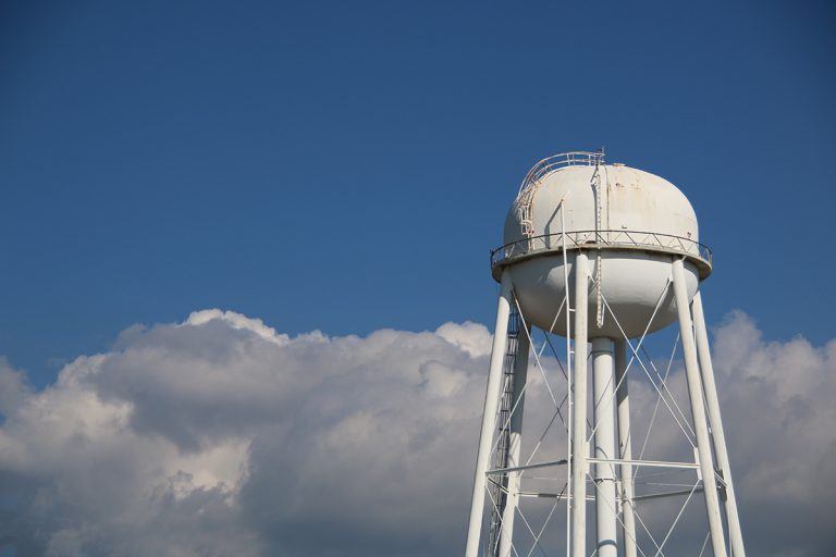 Water Tower with Clouds. (Photo: Adobe Stock │ #214397650 - MitchCoxPhoto)