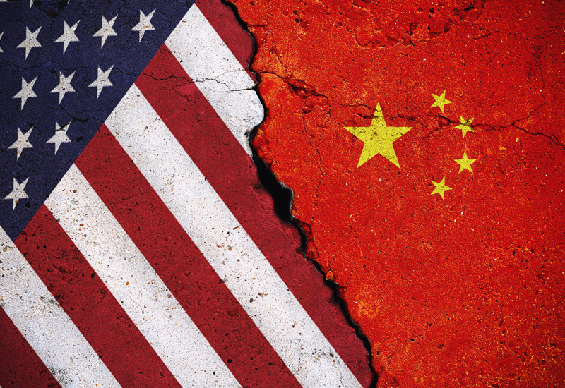 Concrete slab with large cracks, flags of the USA and China. (Photo: Adobe Stock │ #328134219 - Iurii Gagarin)