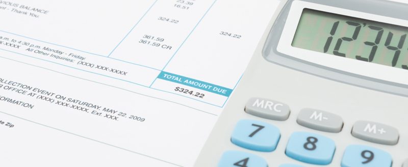 Unpaid utility bill and calculator over it (Photo: Adobe Stock │ #108643636 - niyazz)