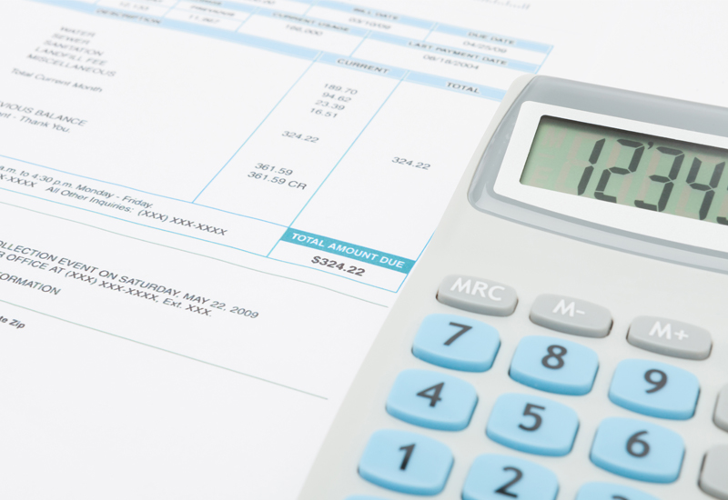 Unpaid utility bill and calculator over it (Photo: Adobe Stock │ #108643636 - niyazz)