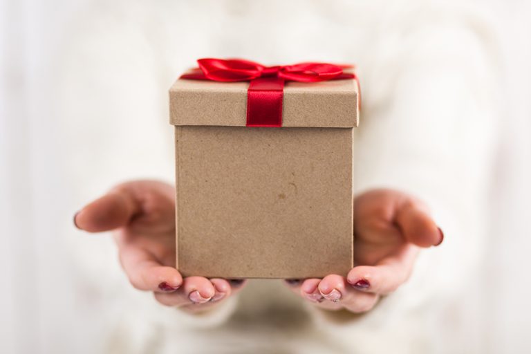 Present box in woman's hands. (Photo: Adobe Stock │ #184466883 - George Dolgikh)