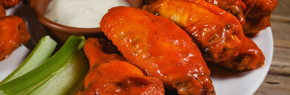 Chicken wings, spicy food and cheese dip. (Photo: Adobe Stock │ #201442289 - Marcos)