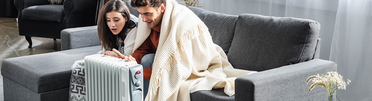 Girlfriend and boyfriend covered with blankest warming up near heater. (Photo: Adobe Stock │ #295094930 - LIGHTFIELD STUDIOS)
