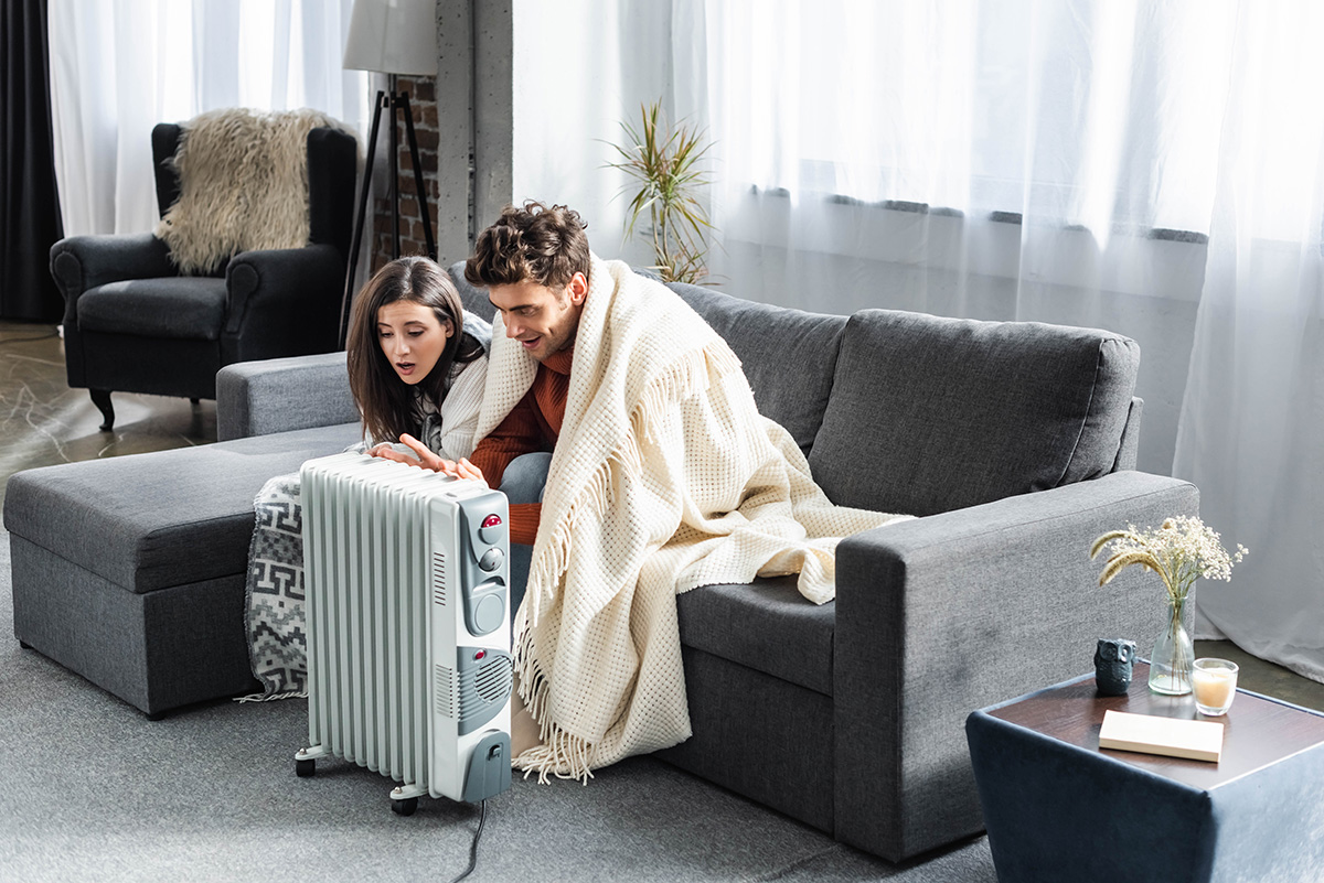 Girlfriend and boyfriend covered with blankest warming up near heater. (Photo: Adobe Stock │ #295094930 - LIGHTFIELD STUDIOS)